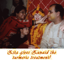 Zita applies turmeric to Zunaid's face.